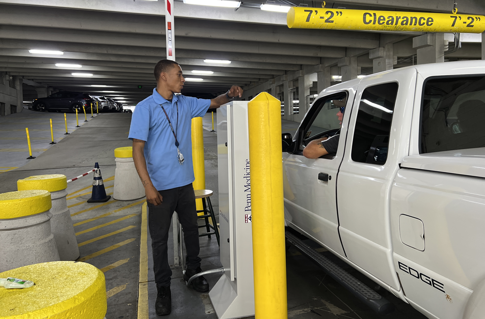 Tommy” Barbieri greets a driver in a truck in the parking garage.
